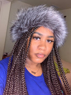 Person wearing a grey furry headband with a neutral background