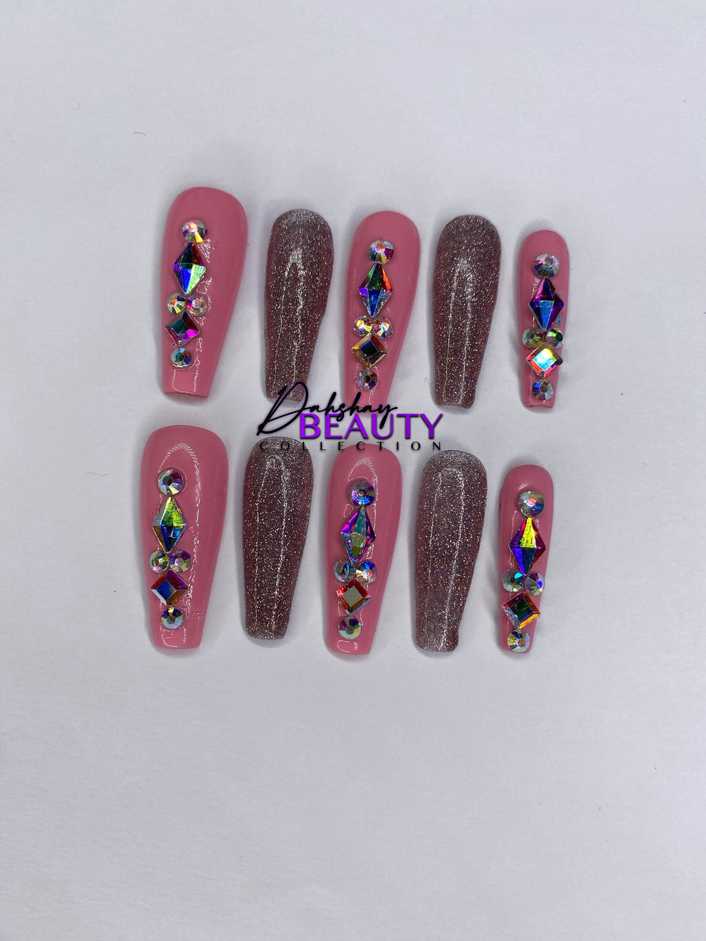 Pink and pink glitter press on nails with rhinestone decorations on a white background.