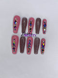 Pink and pink glitter press on nails with rhinestone decorations on a white background.