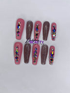 Pink and pink glitter press on nails with rhinestone decorations on a white background.