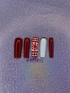 Set of Christmas red and white press on nails with red glitter and a snowflake design on a glittery purple background.
