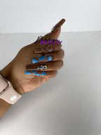 Hand with blue and brown nail design on a white background.
