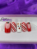 A set of Christmas nails with a reindeer, candy cane and french tip design on a purple satin background.