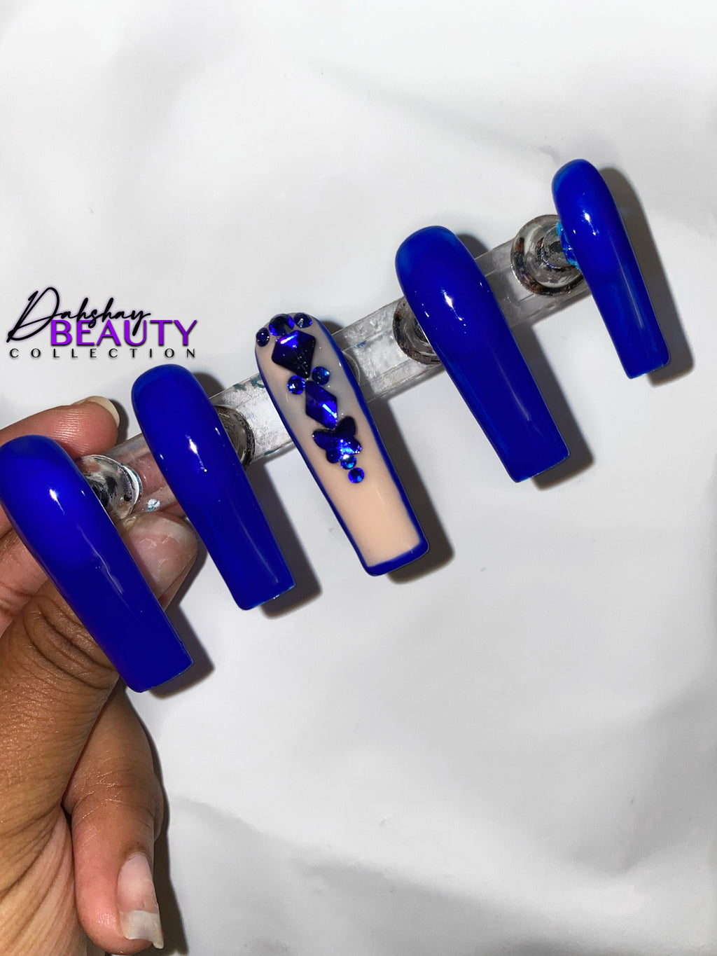 Blue nails with a rhinestone design on a white background