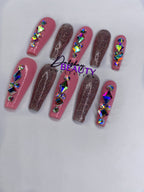 Pink and pink glitter press on nails with rhinestone decorations on a white background.