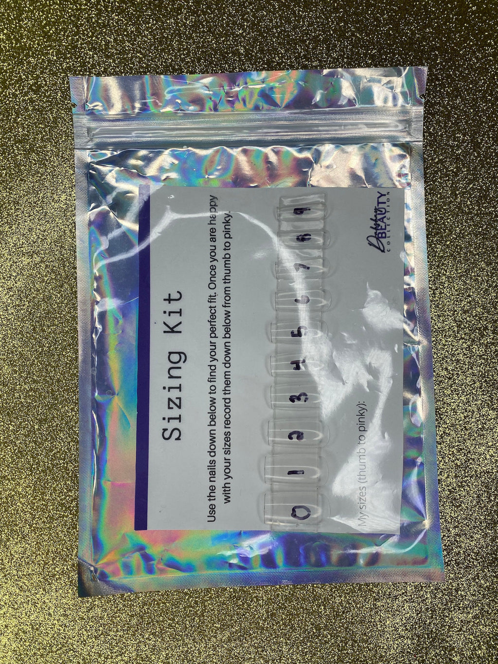 Holographic packaging of a 'Sizing Kit' with measurement tools on a textured gold background.