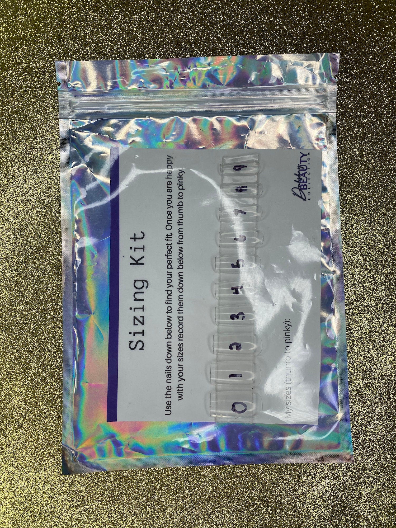 Holographic packaging of a 'Sizing Kit' with measurement tools on a textured gold background.