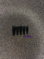 Set of black false nails on a glittery gold background.