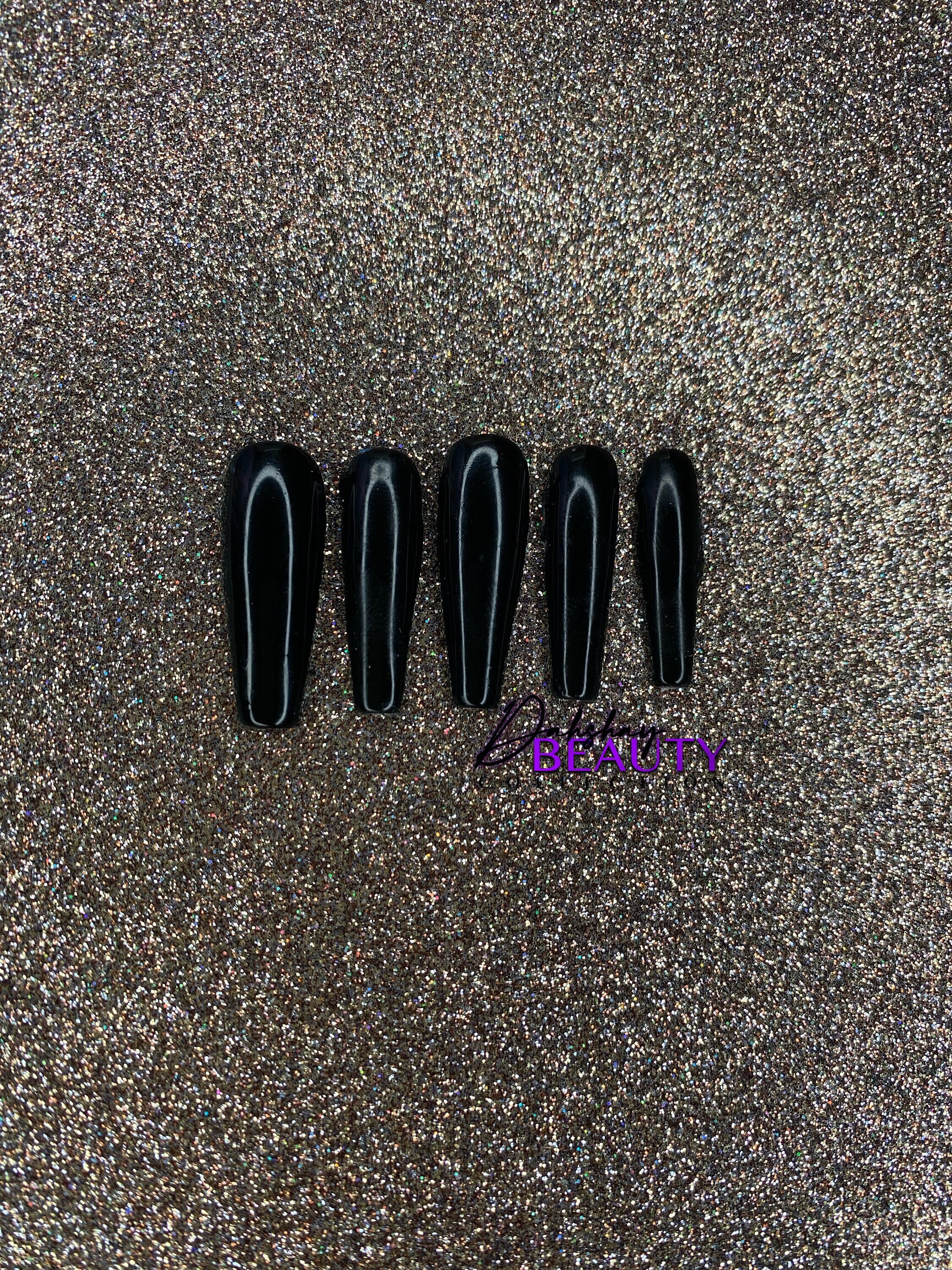 Black press on nails on a gold glitter background