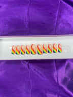 Set of colorful nail art designs on a white card with purple fabric background