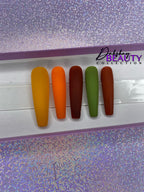 Set of false nails in various Fall colors on a display card with a purple glitter background.