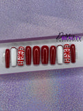 Set of red and white Christmas nail extensions with red glitter and a snowflake design on a purple glittery background.