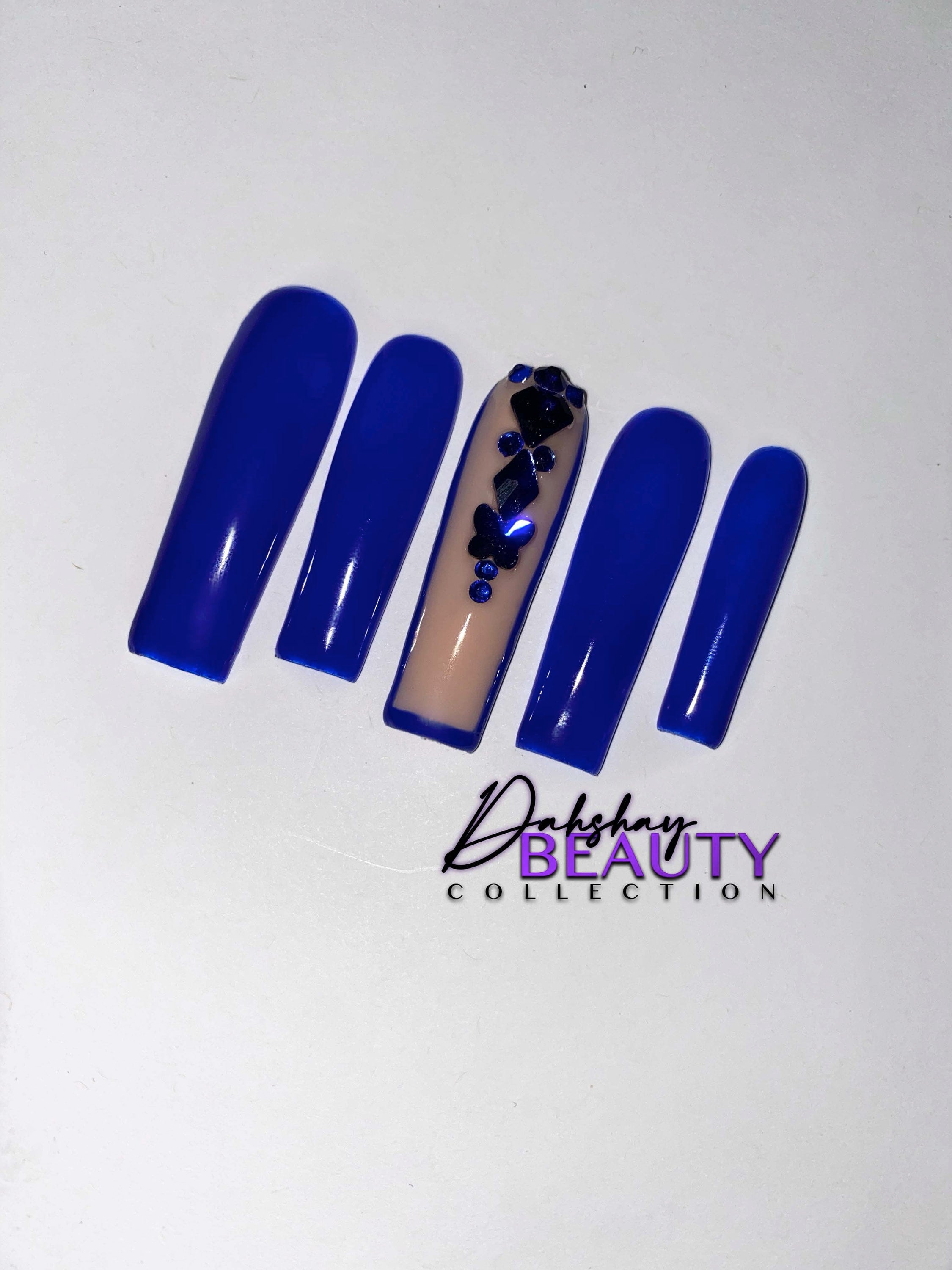 Blue nails with a rhinestone design on a plain white background