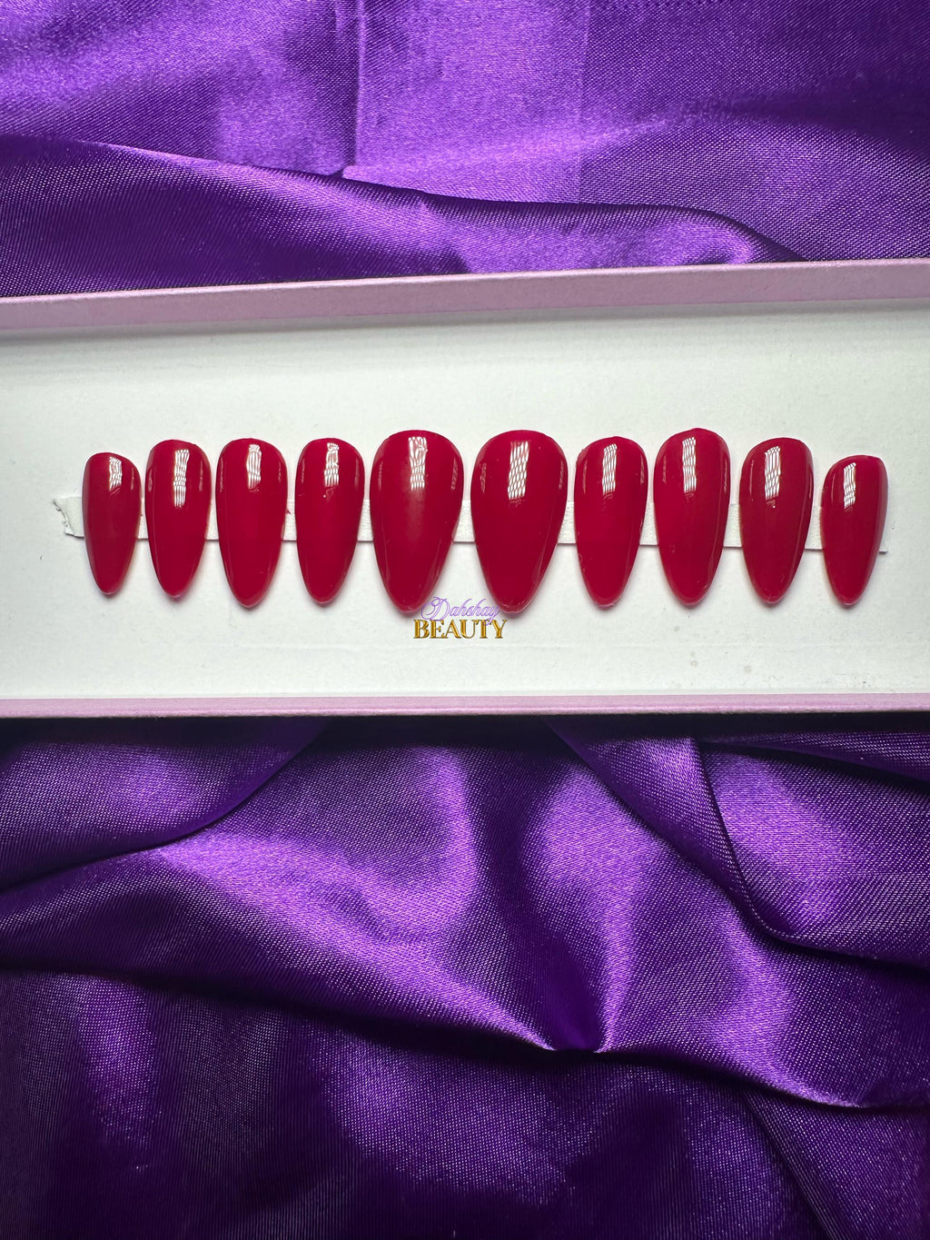 Set of red press on nails on a purple satin background