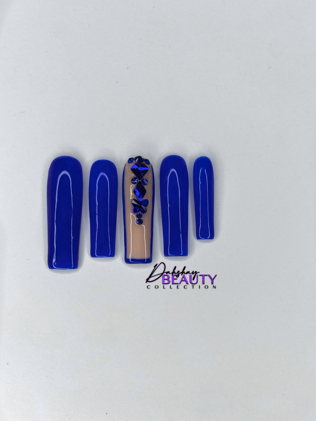 Blue nails with a rhinestone design on a plain white background
