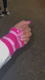 A video of a set of pink floral press on nails on a purple satin background